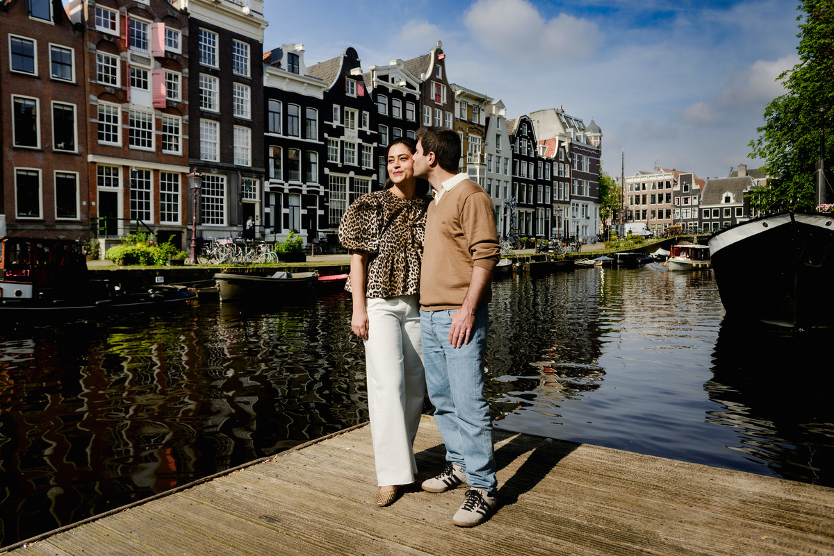 Couple on the canals of Amsterdam with historic houses as a background