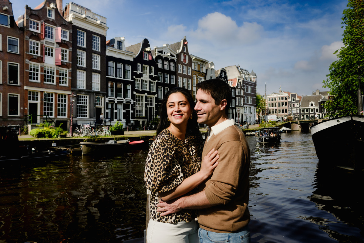Couple on the canals of Amsterdam with historic houses as a background