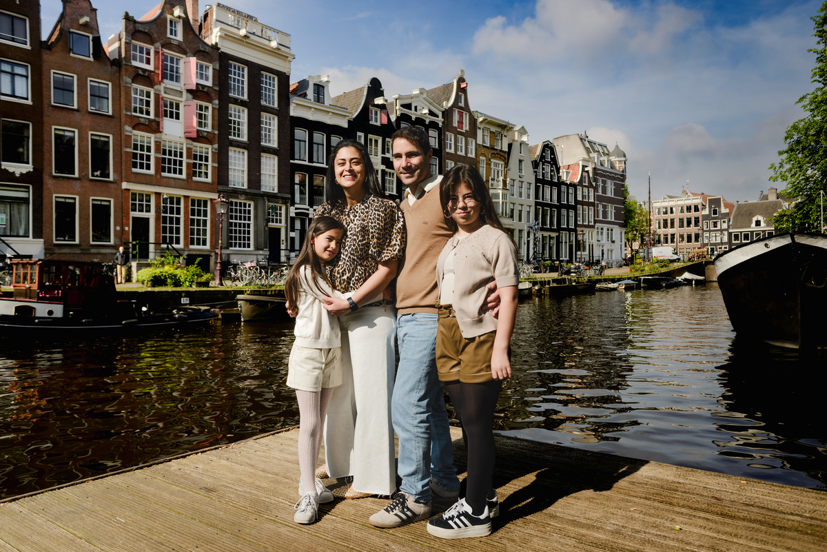 Parents and two daughters laughing together on a sunny day in Amsterdam.
