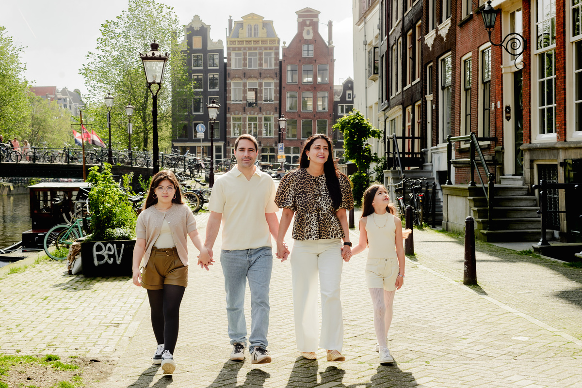 Parents and two daughters laughing together on a sunny day in Amsterdam.