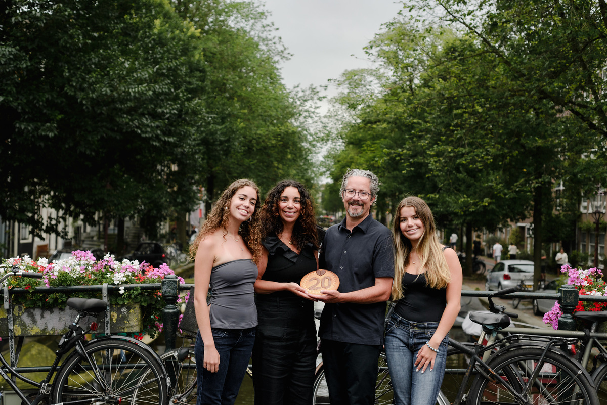 family photo session the the amsterdam canals in the Jordaan district, most famous. Family celebrating a wedding anniversary holding a famous Amsterdam cookie