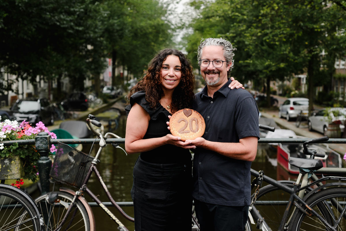 family photo session the the amsterdam canals in the Jordaan district, most famous. Family celebrating a wedding anniversary holding a famous Amsterdam cookie