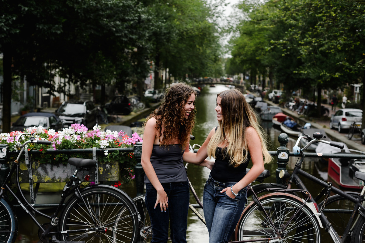 family photo session the the amsterdam canals in the Jordaan district, most famous. Family celebrating a wedding anniversary holding a famous Amsterdam cookie
