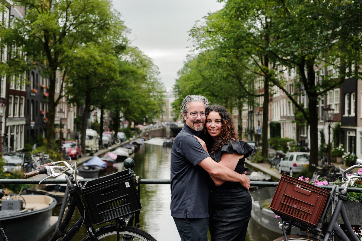 family photo session the the amsterdam canals in the Jordaan district, most famous. Family celebrating a wedding anniversary holding a famous Amsterdam cookie