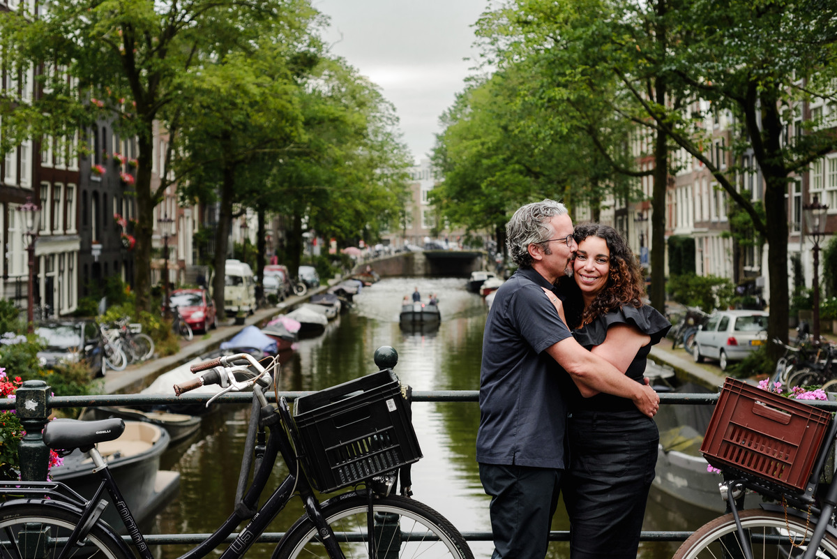 family photo session the the amsterdam canals in the Jordaan district, most famous. Family celebrating a wedding anniversary holding a famous Amsterdam cookie