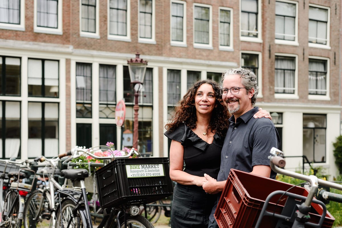 family photo session the the amsterdam canals in the Jordaan district, most famous. Family celebrating a wedding anniversary holding a famous Amsterdam cookie