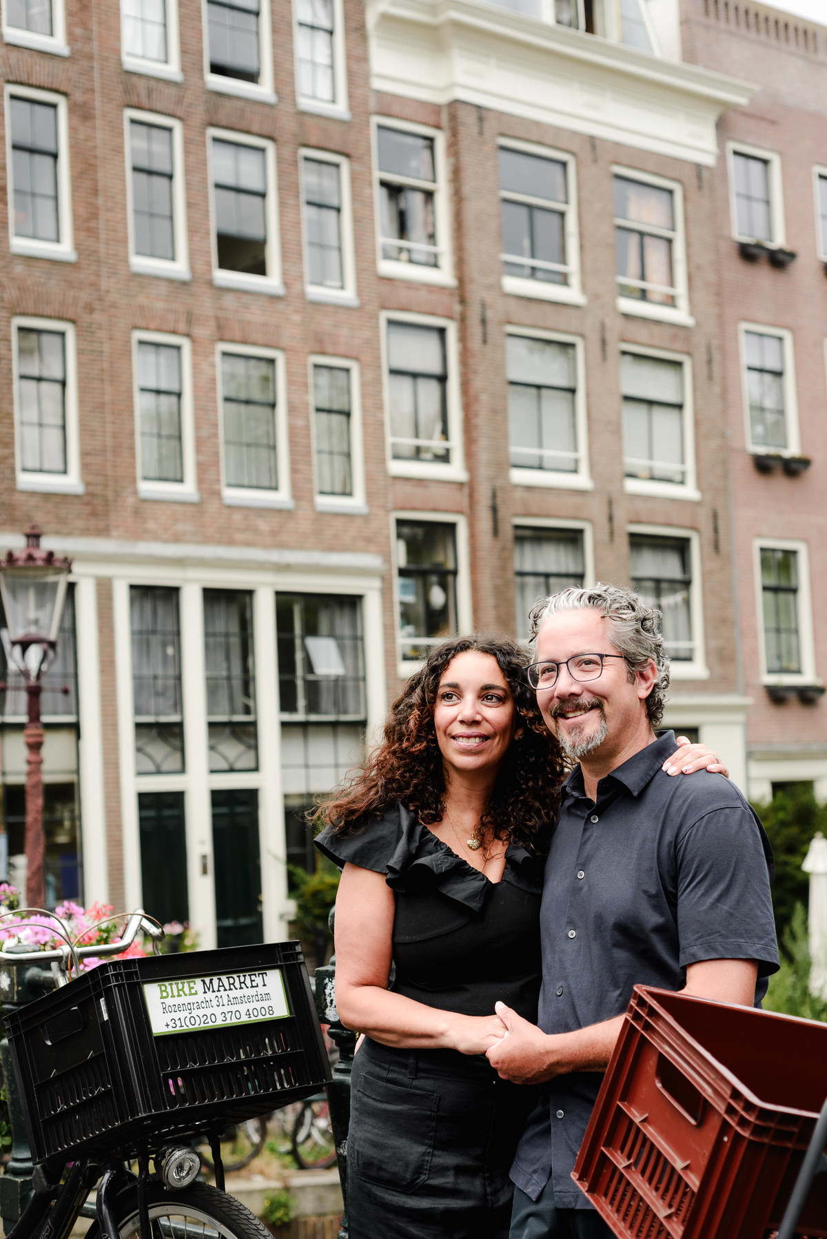 family photo session the the amsterdam canals in the Jordaan district, most famous. Family celebrating a wedding anniversary holding a famous Amsterdam cookie