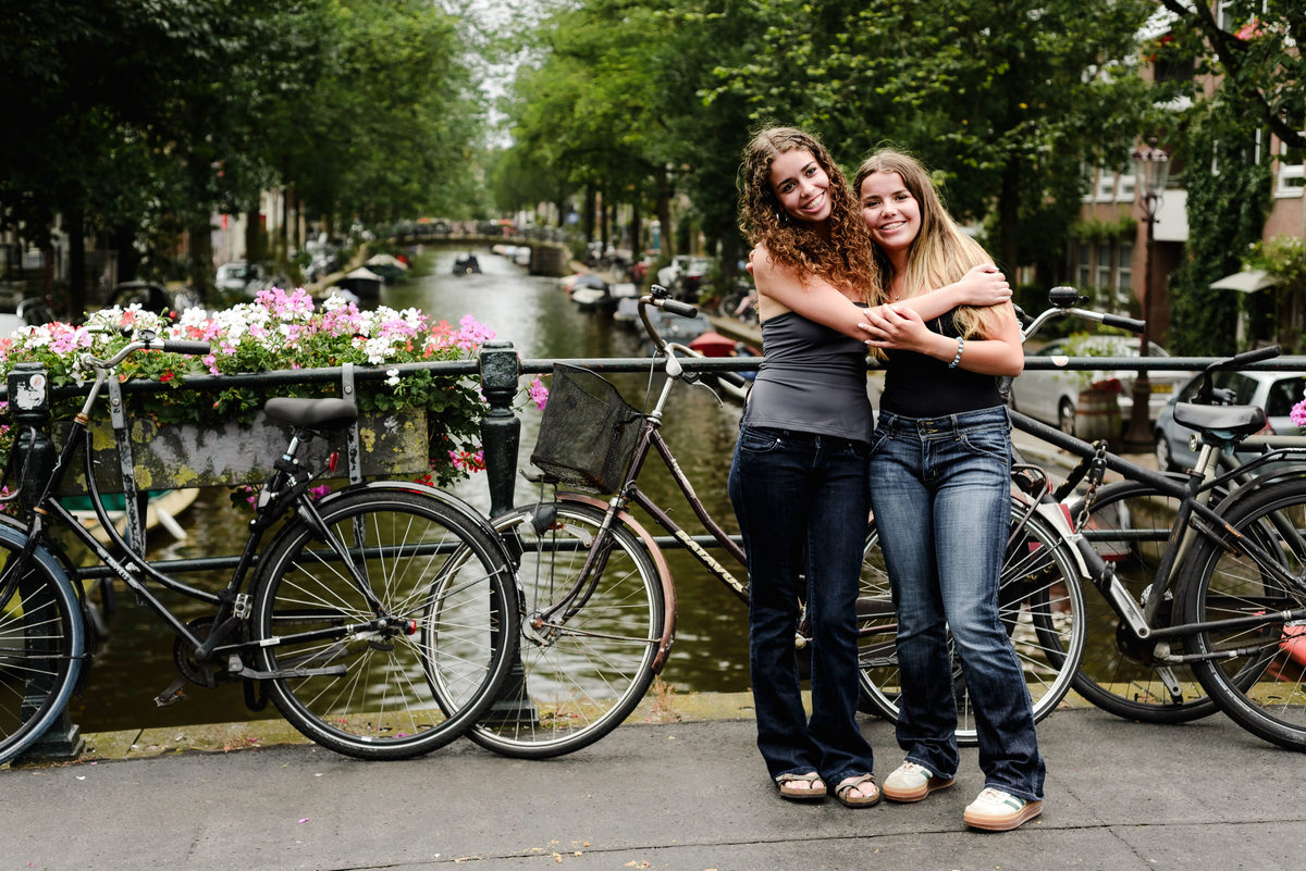 family photo session the the amsterdam canals in the Jordaan district, most famous. Family celebrating a wedding anniversary holding a famous Amsterdam cookie