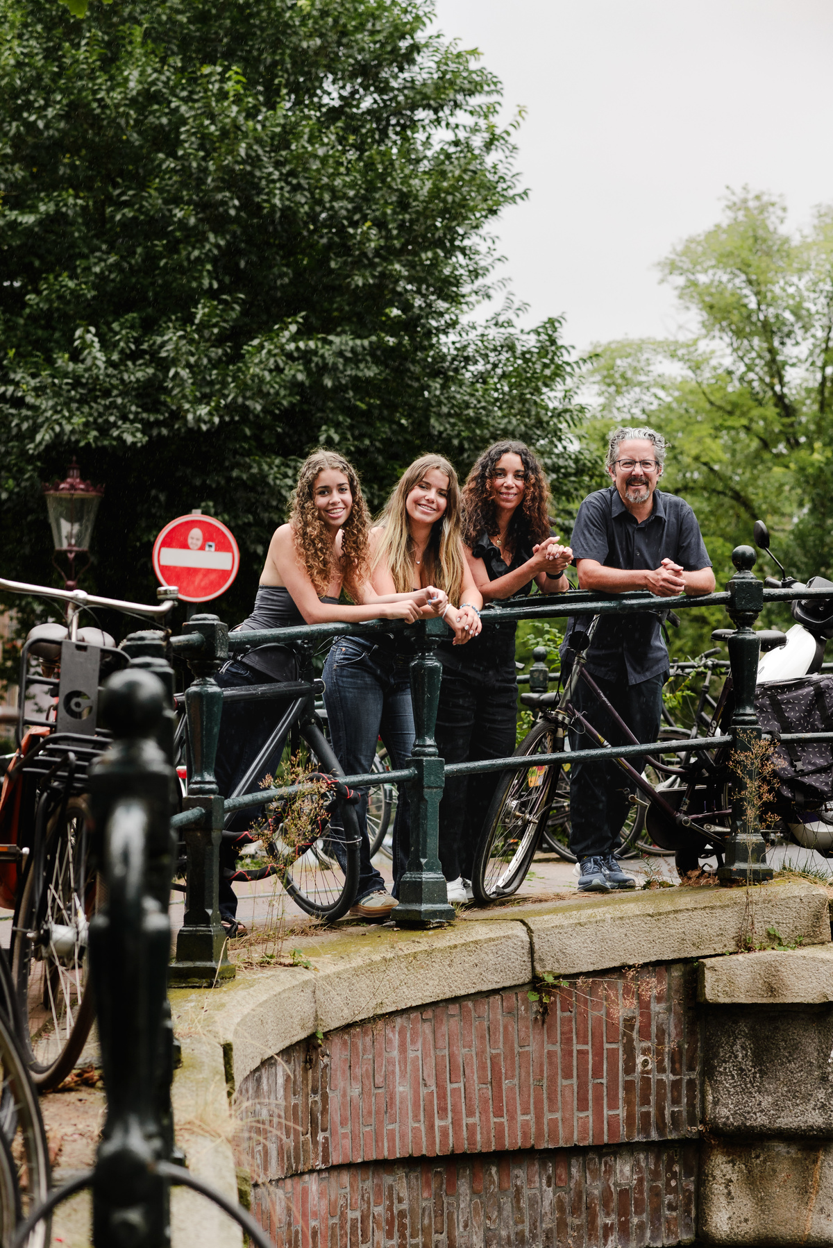 family photo session the the amsterdam canals in the Jordaan district, most famous. Family celebrating a wedding anniversary holding a famous Amsterdam cookie