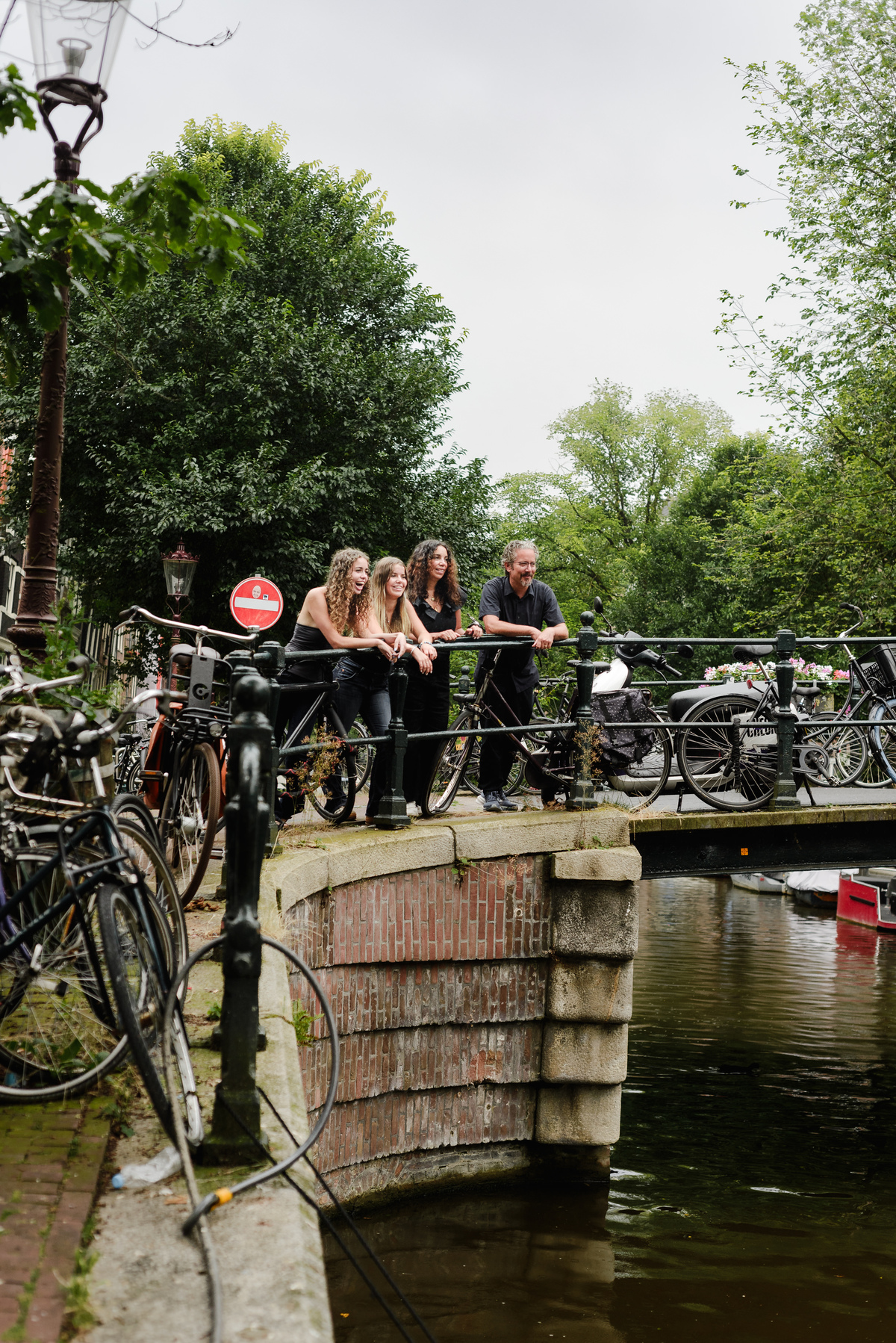 family photo session the the amsterdam canals in the Jordaan district, most famous. Family celebrating a wedding anniversary holding a famous Amsterdam cookie
