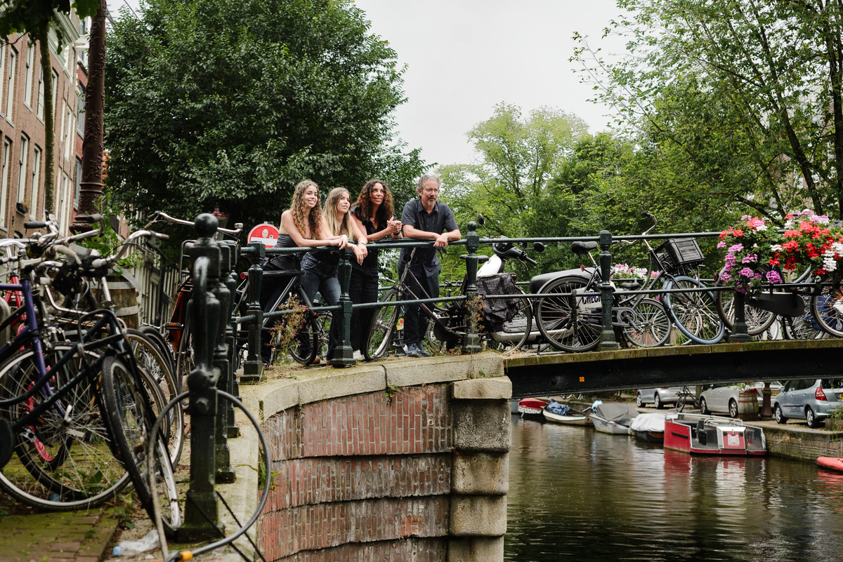 family photo session the the amsterdam canals in the Jordaan district, most famous. Family celebrating a wedding anniversary holding a famous Amsterdam cookie