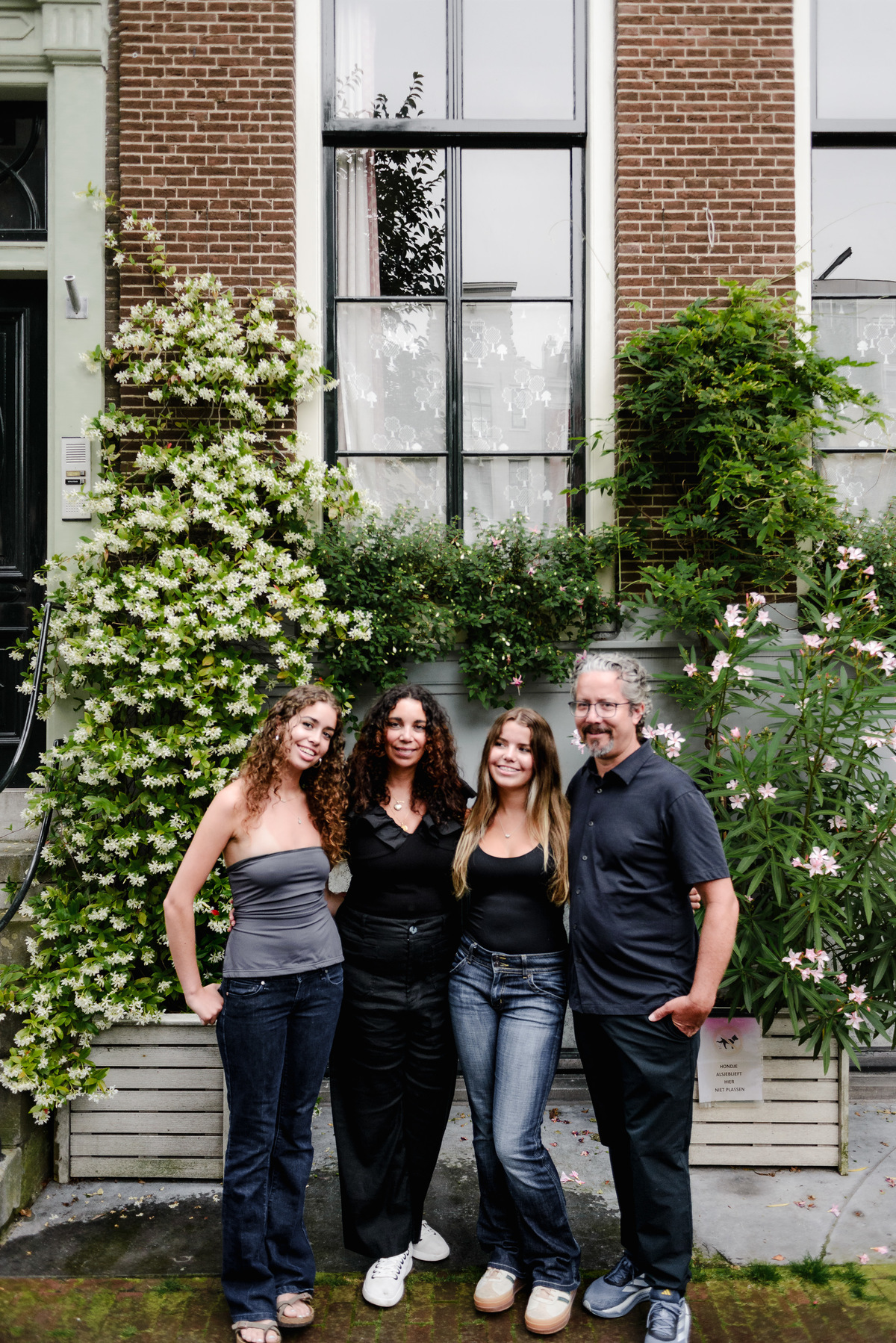 family photo session the the amsterdam canals in the Jordaan district, most famous. Family celebrating a wedding anniversary holding a famous Amsterdam cookie
