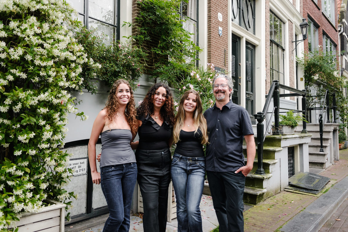 family photo session the the amsterdam canals in the Jordaan district, most famous. Family celebrating a wedding anniversary holding a famous Amsterdam cookie