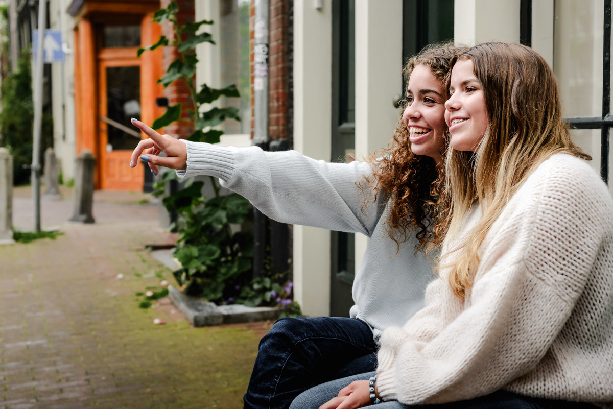 family photo session the the amsterdam canals in the Jordaan district, most famous. Family celebrating a wedding anniversary holding a famous Amsterdam cookie