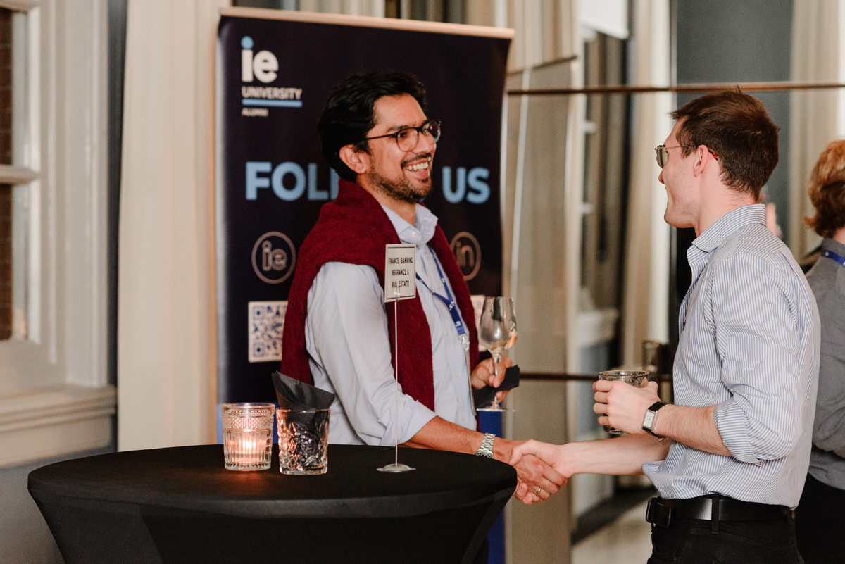 Two professionals at IE University’s Amsterdam networking event having a focused conversation, highlighting meaningful connections.