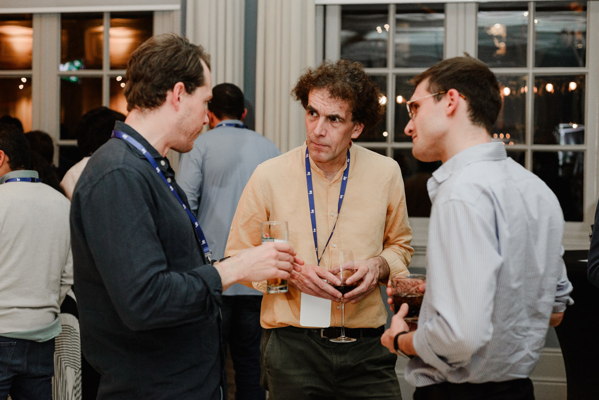 Group of professionals networking at IE University’s Alumni Networking Night in Amsterdam, smiling and engaged in conversation during one of the targeted networking rounds.