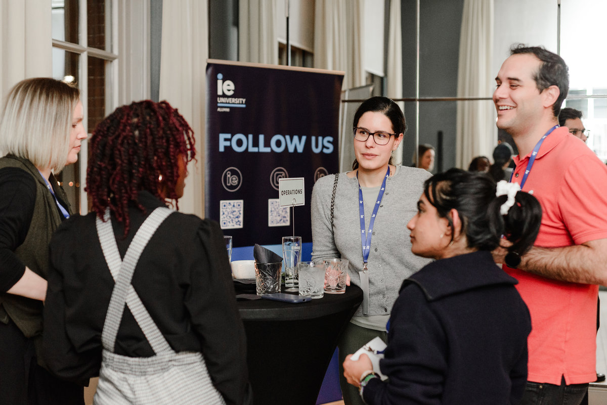Group of professionals networking at IE University’s Alumni Networking Night in Amsterdam, smiling and engaged in conversation during one of the targeted networking rounds.