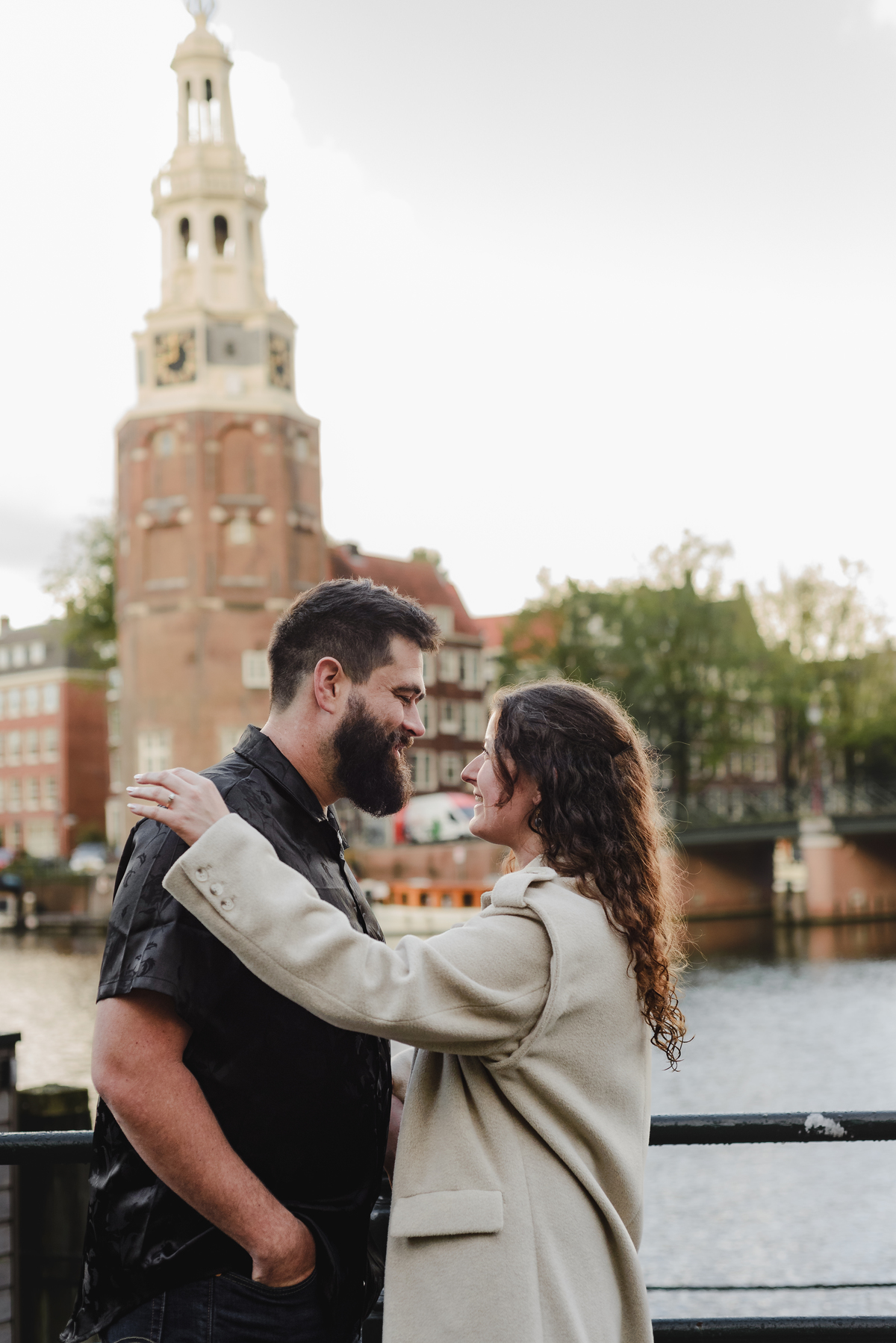 Close-up of the couple sharing a tender look against a backdrop of Amsterdam’s iconic brick walls, creating an intimate engagement photo.