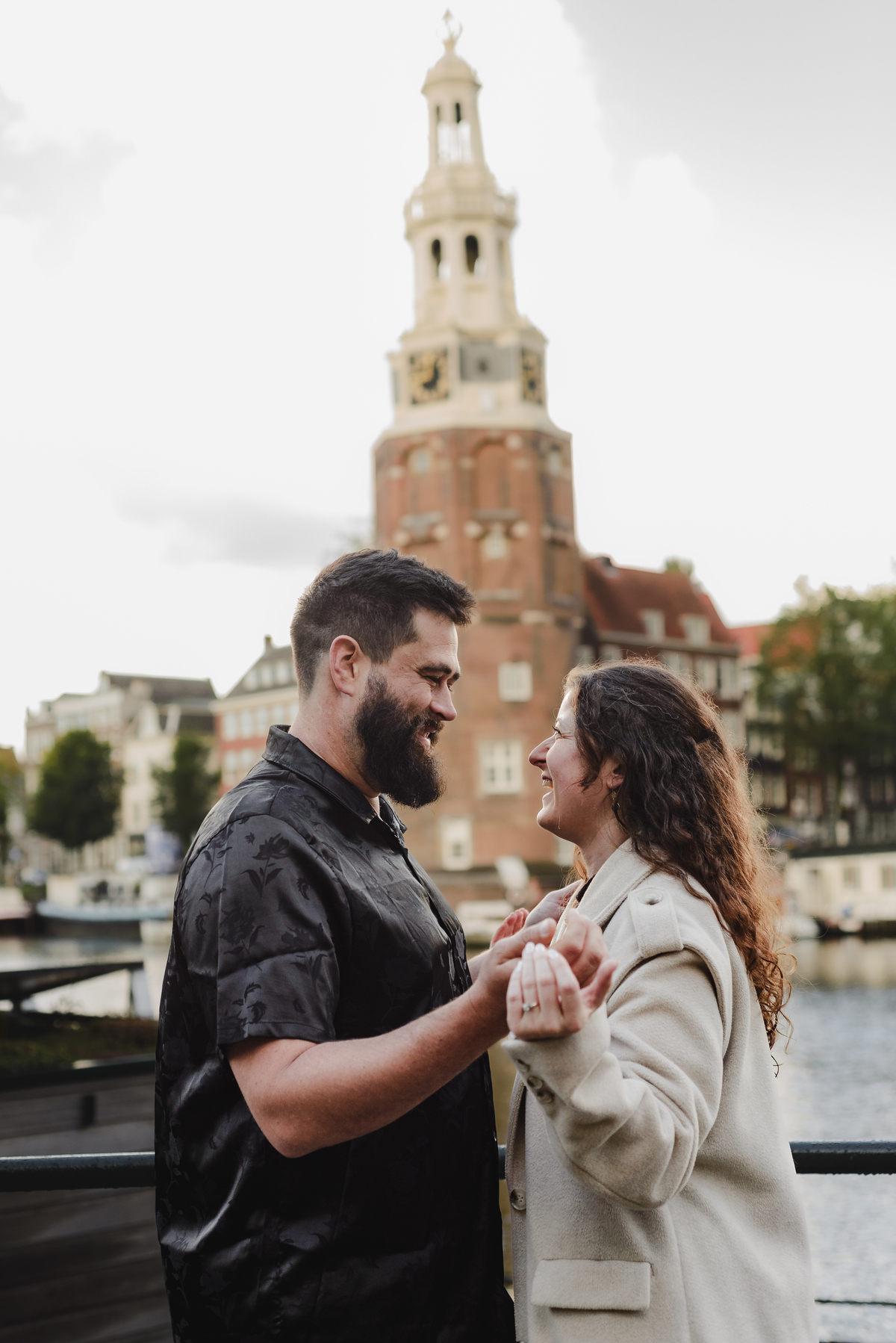 Close-up of the couple sharing a tender look against a backdrop of Amsterdam’s iconic brick walls, creating an intimate engagement photo.