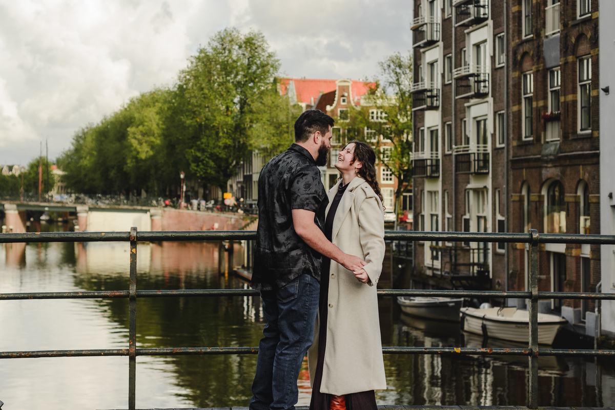 Close-up of the couple sharing a tender look against a backdrop of Amsterdam’s iconic brick walls, creating an intimate engagement photo.