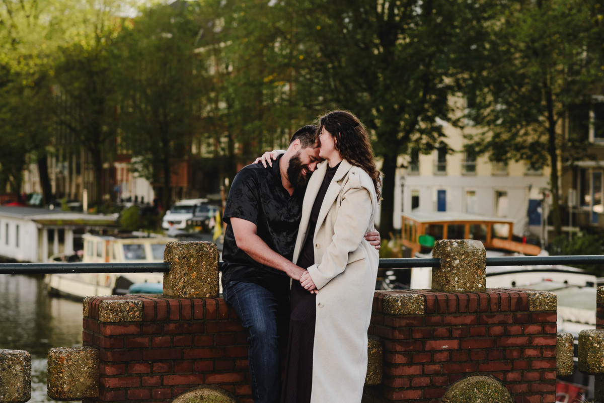 Close-up of the couple sharing a tender look against a backdrop of Amsterdam’s iconic brick walls, creating an intimate engagement photo.