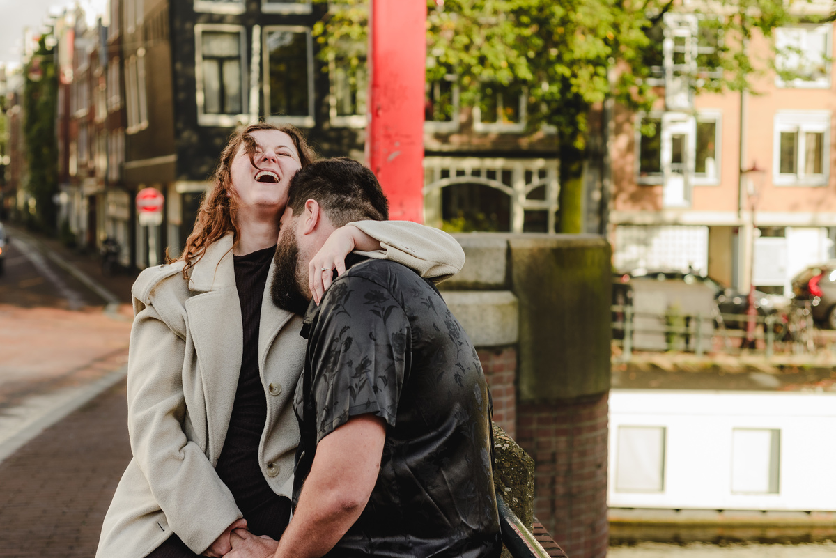 Close-up of the couple sharing a tender look against a backdrop of Amsterdam’s iconic brick walls, creating an intimate engagement photo.
