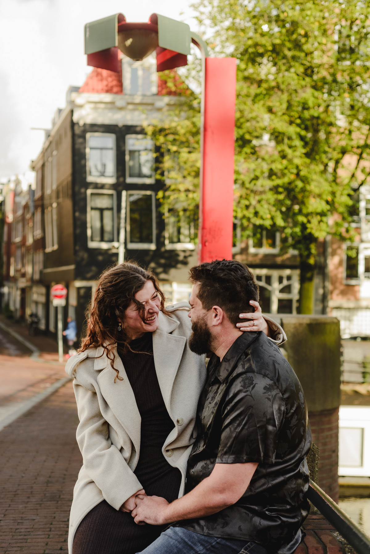 Close-up of the couple sharing a tender look against a backdrop of Amsterdam’s iconic brick walls, creating an intimate engagement photo.