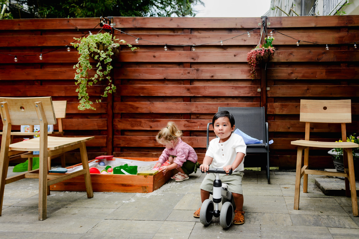 Guests enjoying a lively conversation at an outdoor table, surrounded by lush greenery and sunny weather during the birthday celebration.