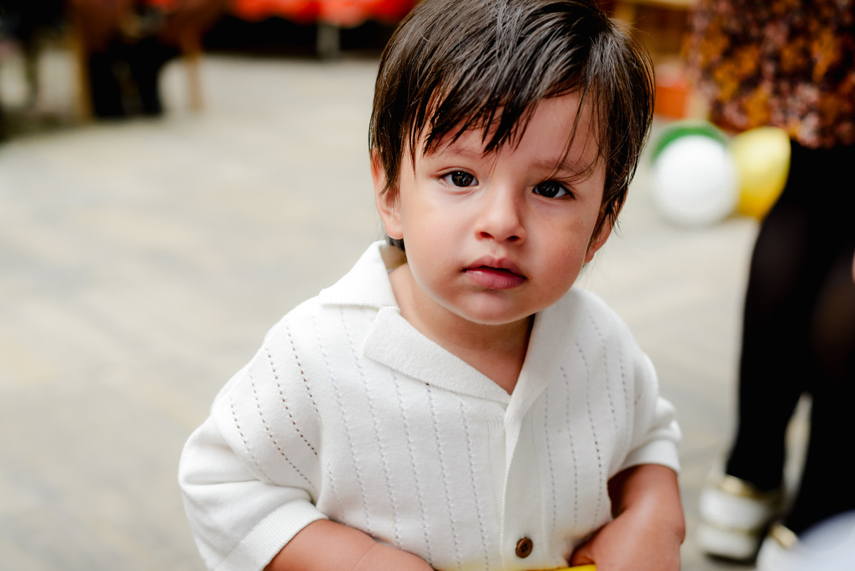 Birthday boy running joyfully in the garden, holding a small toy, with jungle-themed decorations in the background