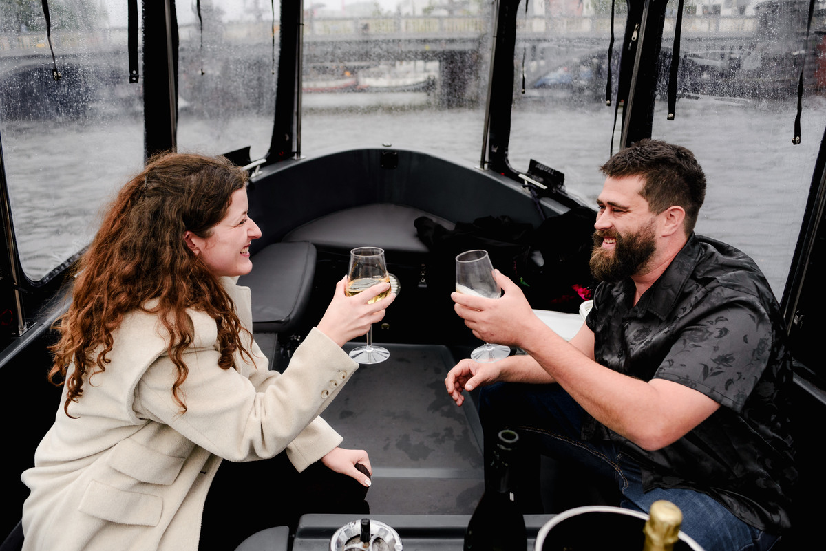 Behind-the-scenes shot of the photographer capturing a proposal from the boat’s deck, blending into the crew