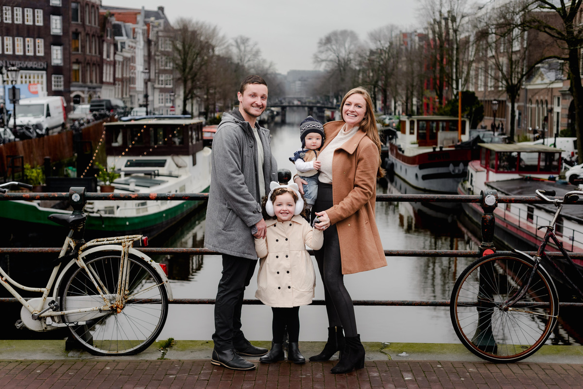 Side-by-side on the bridge, the family beams with happiness — a classic vacation shot with postcard-worthy views.