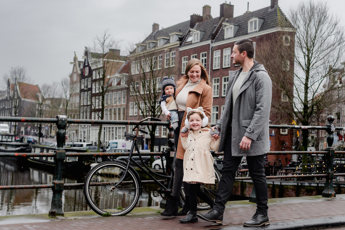 Framed by canal houses and moored boats, this joyful portrait captures the essence of a family adventure in the heart of Amsterdam.