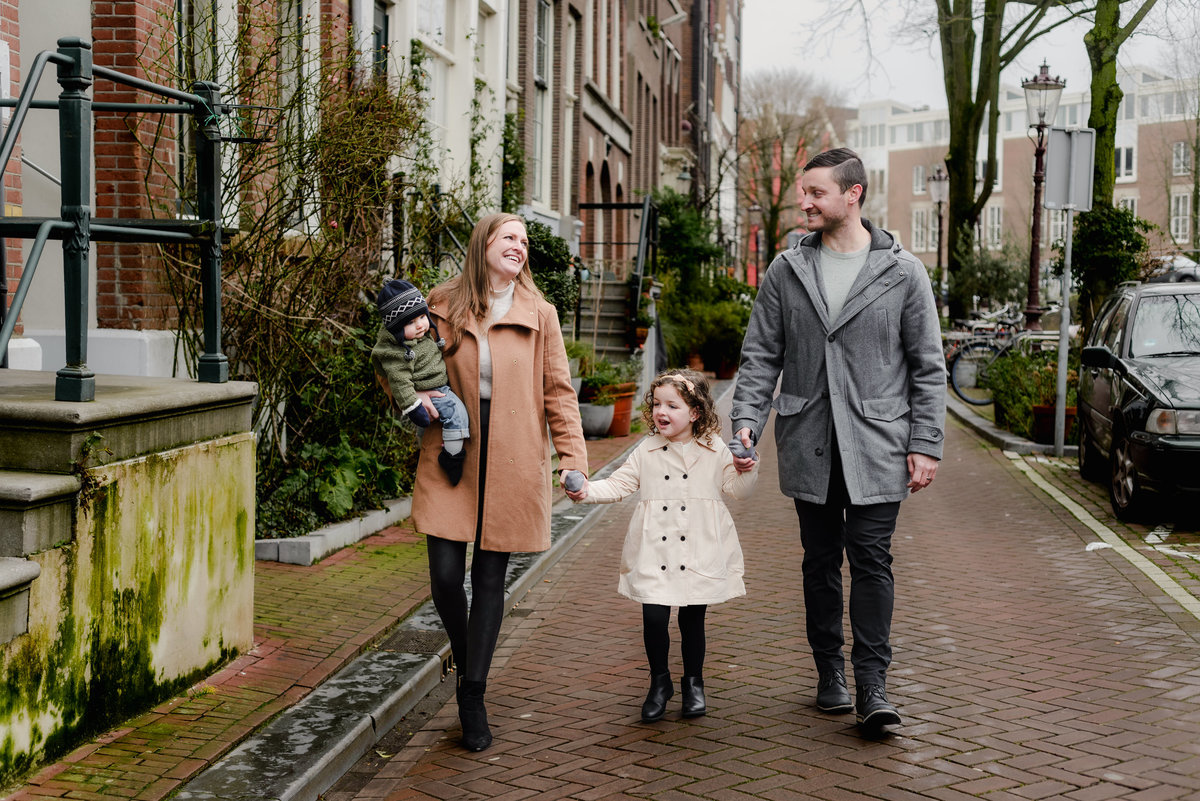 Happy and relaxed, the family takes a winter stroll through Amsterdam’s leafy streets, captured in mid-conversation.