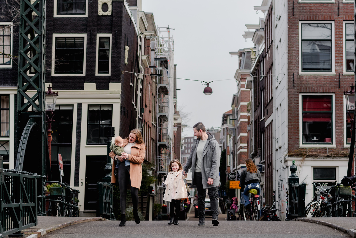 Street-style family photo in the heart of Jordaan, showing real connection and joy in a natural urban setting.