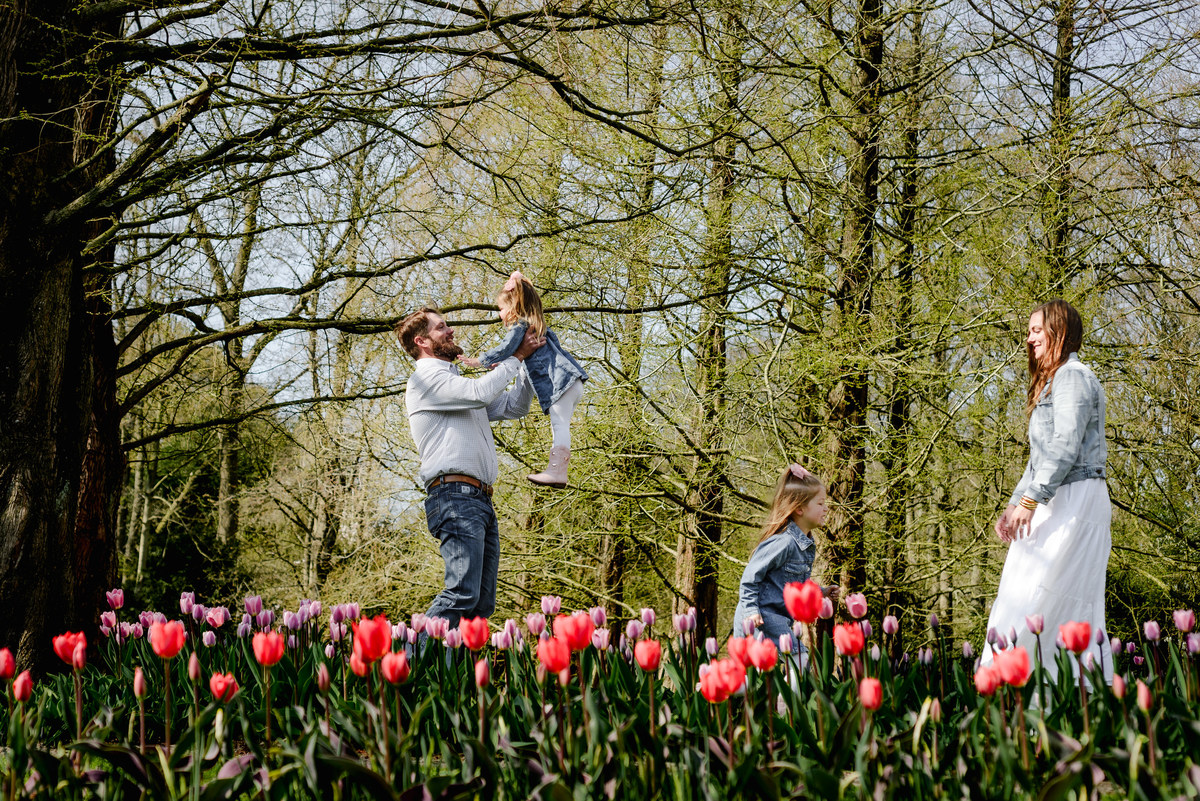 A springtime family photo session at Keukenhof Gardens in early April, showcasing playful moments among vibrant tulip fields and scenic woodland backdrops.