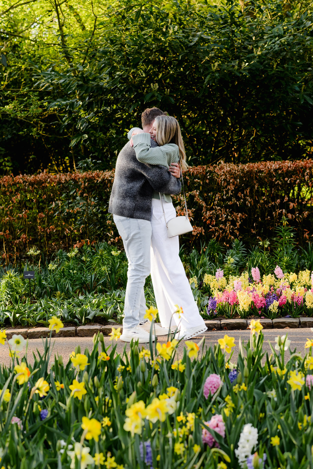 Couple embraces after a successful proposal, surrounded by colorful spring blooms in Keukenhof Gardens.