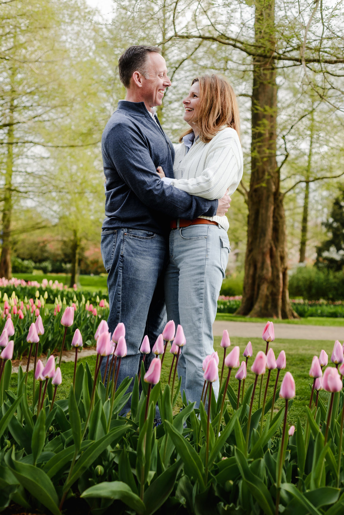With wide smiles, the couple poses together in a sea of tulips, their joy captured amid Keukenhof's vibrant scenery.