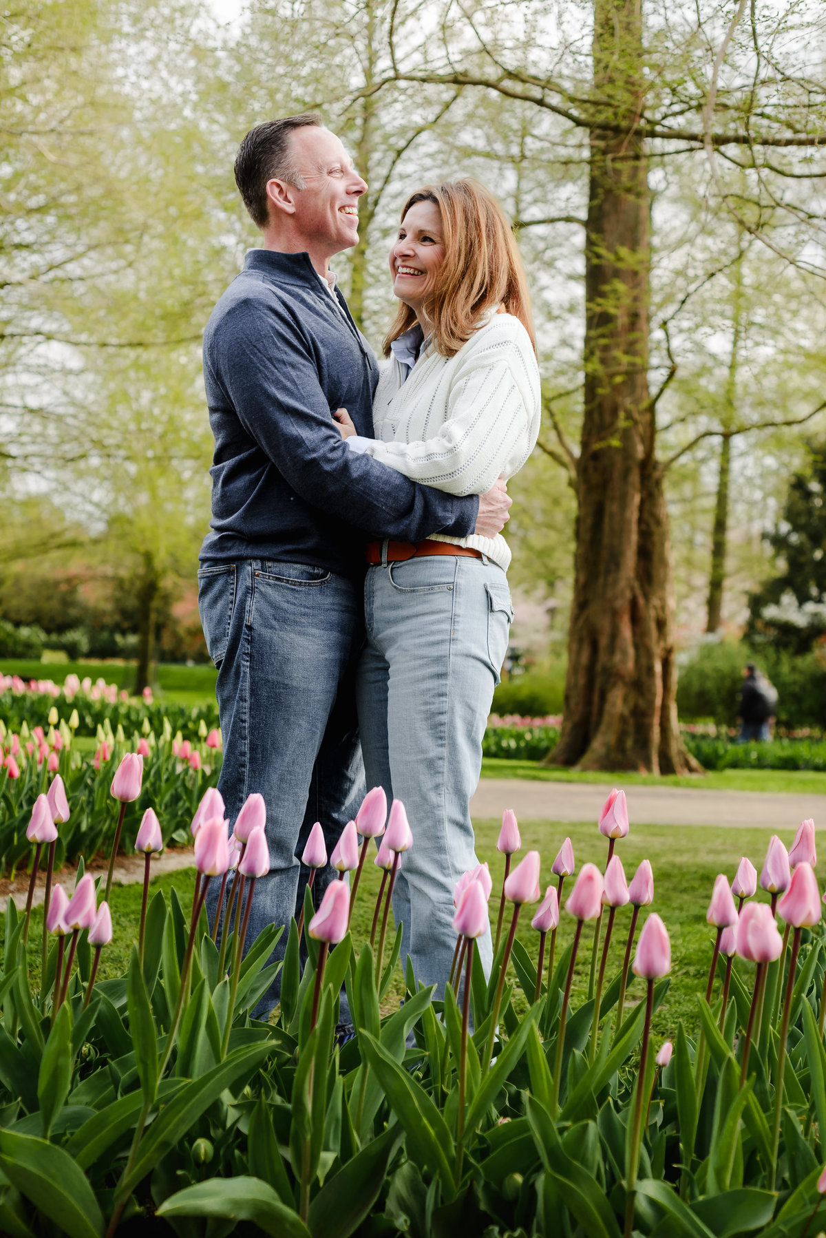 With wide smiles, the couple poses together in a sea of tulips, their joy captured amid Keukenhof's vibrant scenery.