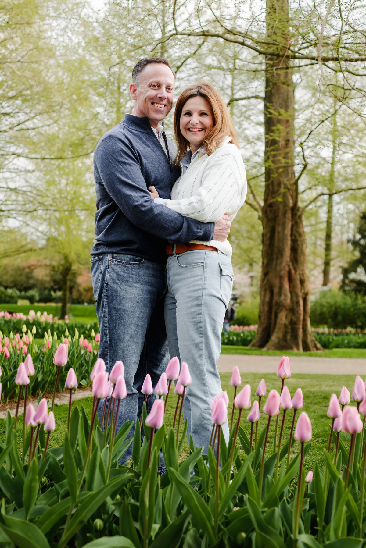 With wide smiles, the couple poses together in a sea of tulips, their joy captured amid Keukenhof's vibrant scenery.