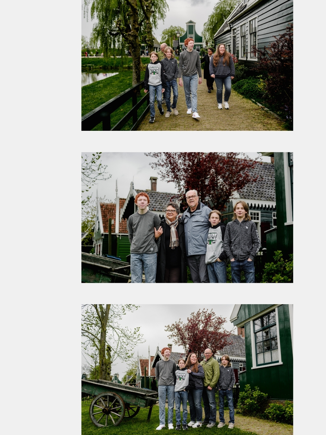 Family walking through cobblestone streets and standing by green historic homes during a photo session at Zaanse Schans.