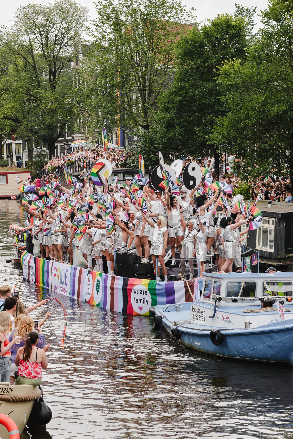 Wide-angle view of boats arriving at the canal parade, showing energy and movement in the scene.