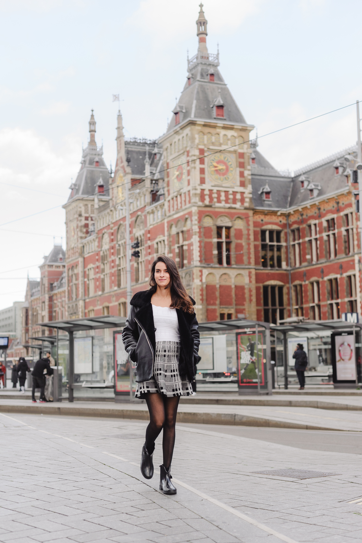 Portrait of a woman on holiday standing in front of Amsterdam Central Station during an Explorer photography tour