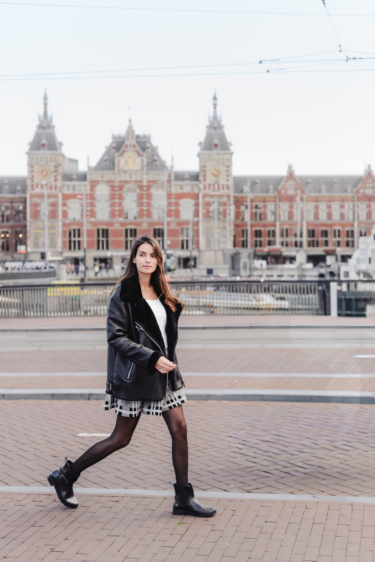 Traveler walking along the waterfront near Amsterdam Central Station during a private photo session in the city