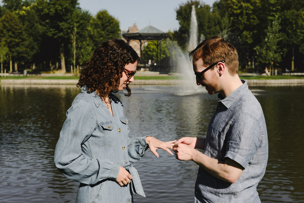 Surprise engagement proposal in Amsterdam, The Netherlands. Man is putting the ring after she said yes to the proposal