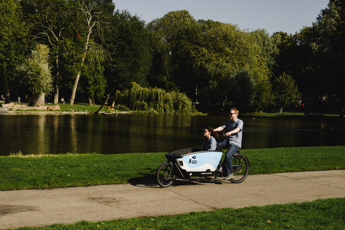 Couple arriving on cargo bike Urban Arrow at Oosterpark in Amsterdam, The Netherlands