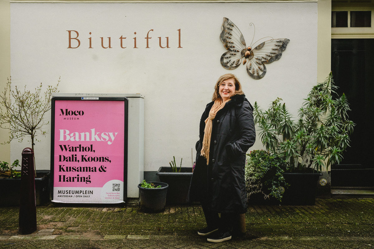 Woman celebrating her birthday in Amsterdam, posing alone in front a wall during a winter photo session.