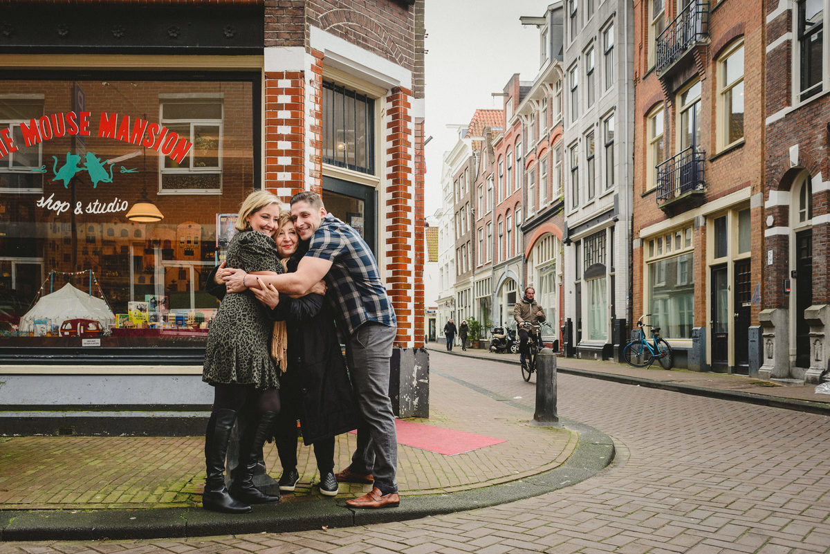 Relaxed family portrait of adult siblings and their mother in Amsterdam, photographed on a quiet Amsterdam street.