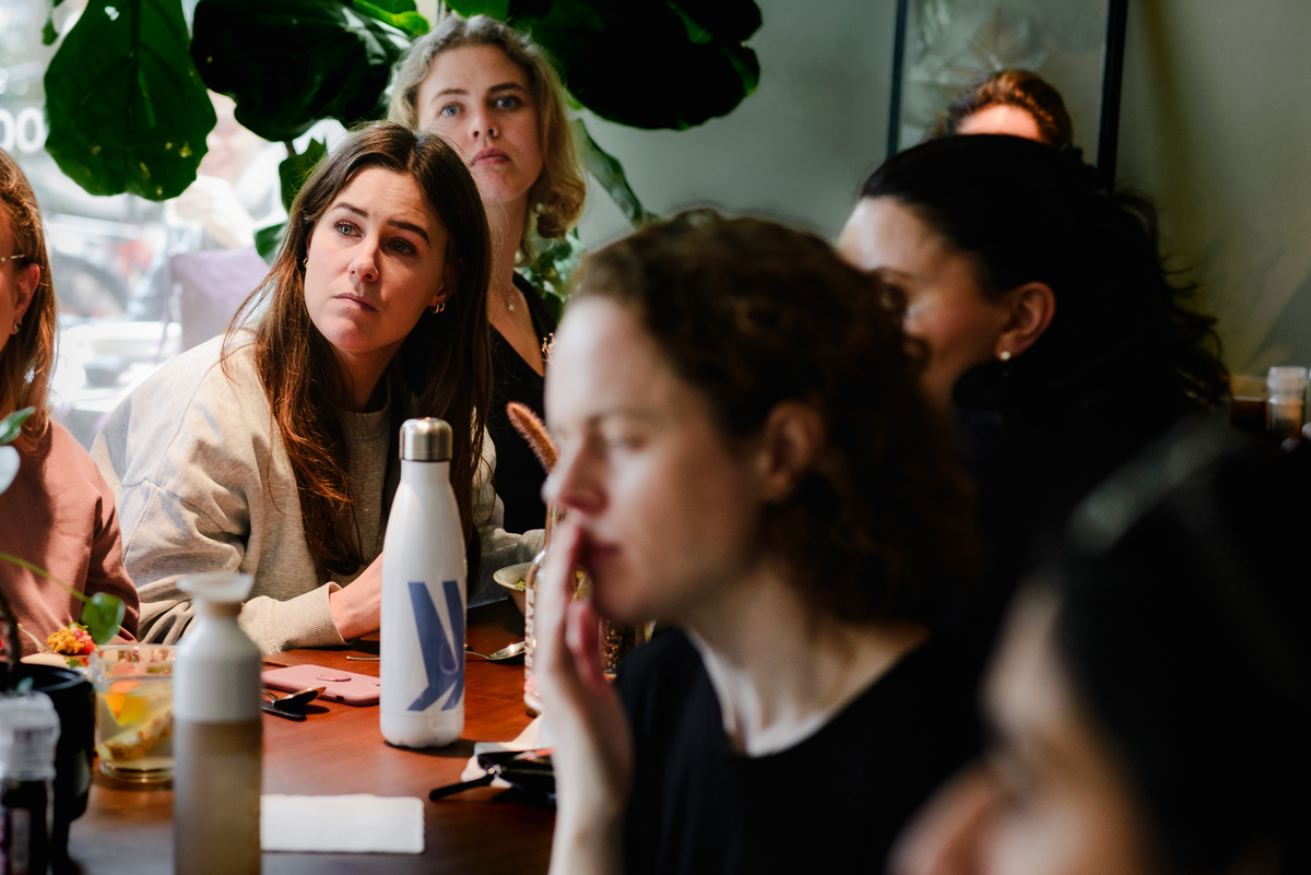 Guests reacting during a conversation at an intimate Amsterdam event, photographed without posing.