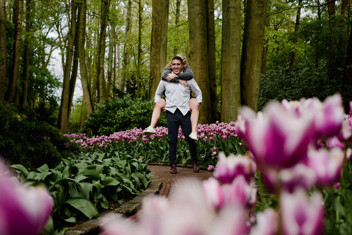 Engaged couple posing playfully in tulip gardens at Keukenhof, Netherlands