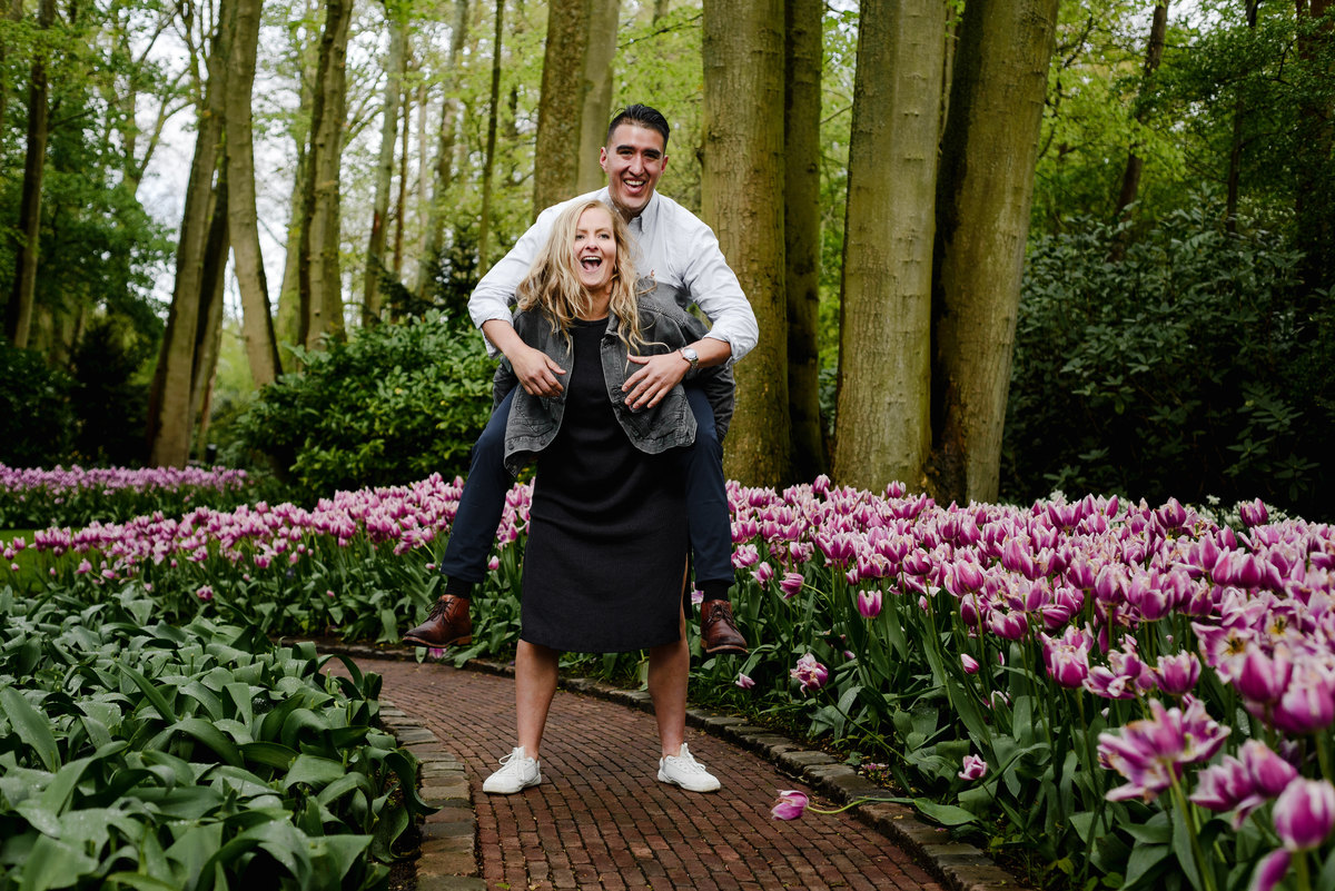 Newly engaged couple laughing together in spring flower garden at Keukenhof